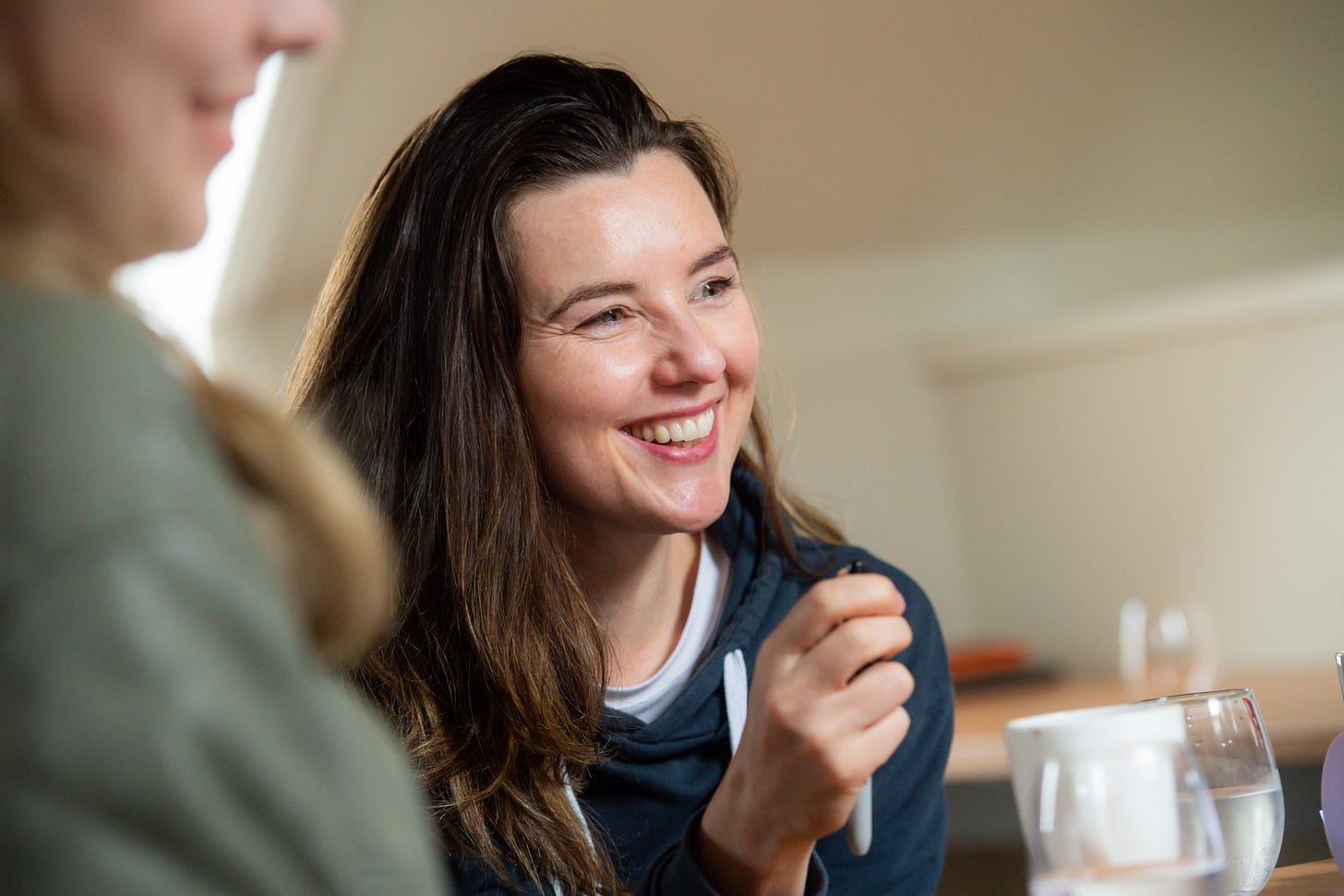 A candid shot of Sarah during a workshop, smiling over the table