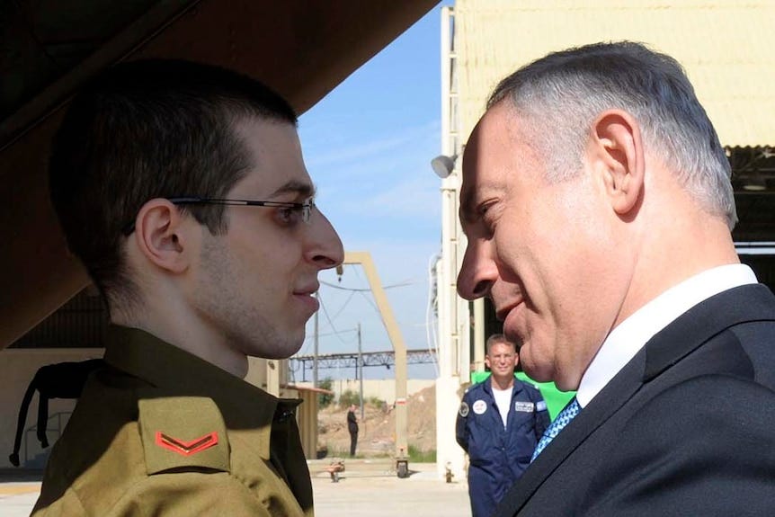 Israeli PM Benjamin Netanyahu (R) greets freed Israeli soldier Gilad Shalit at Tel Nof air base on October 18, 2011.