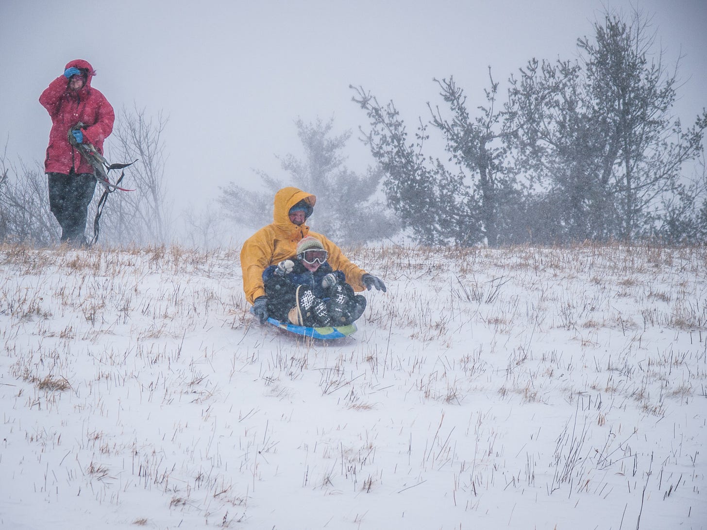 Man and boy sledding down hill
