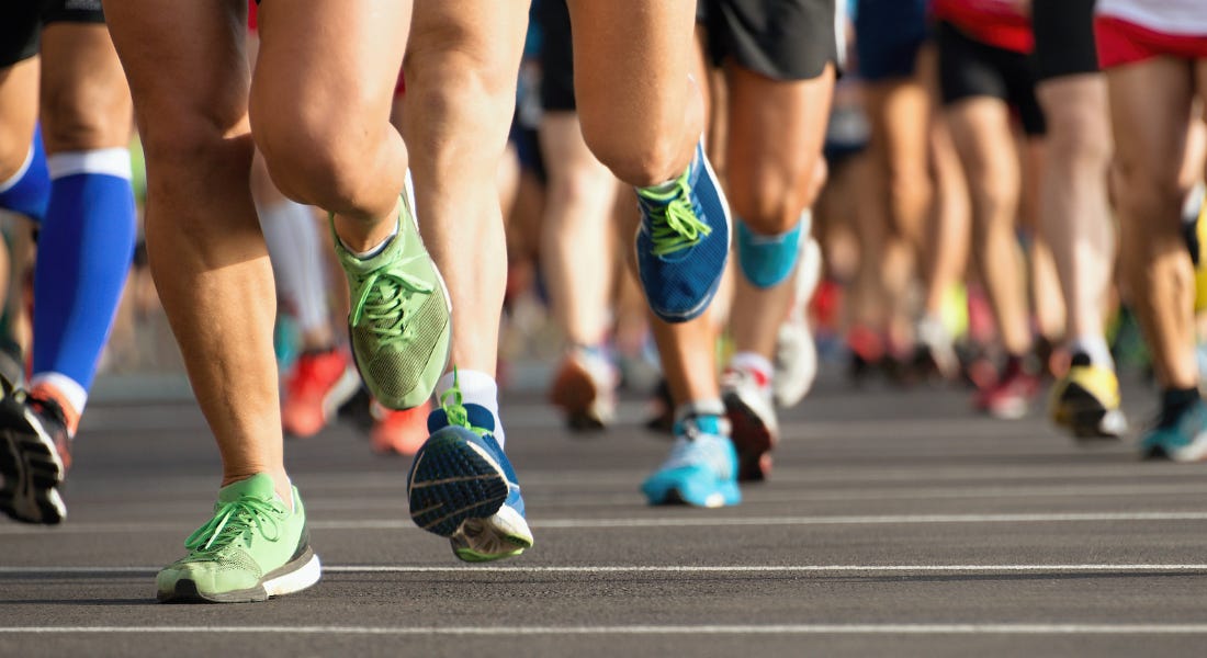 A close-up of runners' legs wearing colourful trainers