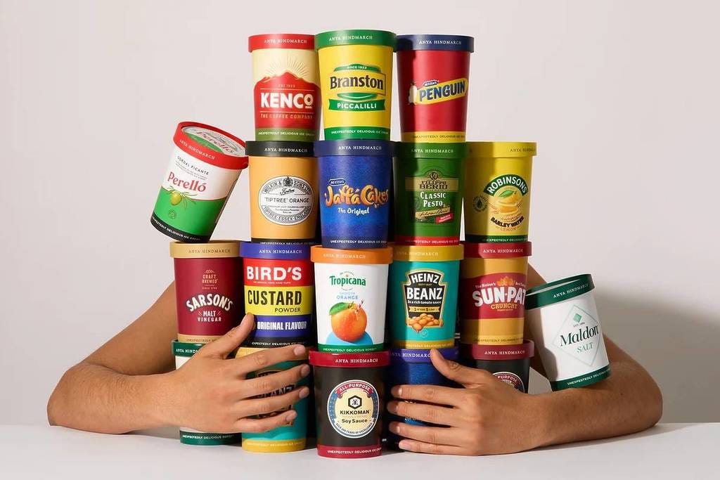 someone with their arms wrapped around a variety of pint containers of ice cream in wacky flavours