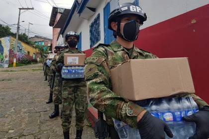 Soldados del Ejército de Colombia usando tapabocas y guantes cargan cajas con alimenros y agua para entrgar a familias pobres durante la cuarentena por coronavirus en Bogotá, Colombia,  17 de abril, 2020. REUTERS/Luis Jaime Acosta