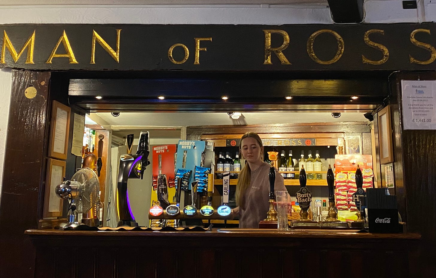 A bar with beer taps and a lady