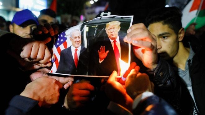 Palestinian protesters burn pictures of US President Donald Trump and Israel's Prime Minister Benjamin Netanyahu during a demonstration in the West Bank city of Ramallah Palestinian protesters burn pictures of US President Donald Trump and Israel's Prime Minister Benjamin Netanyahu during a demonstration in the West Bank city of Ramallah