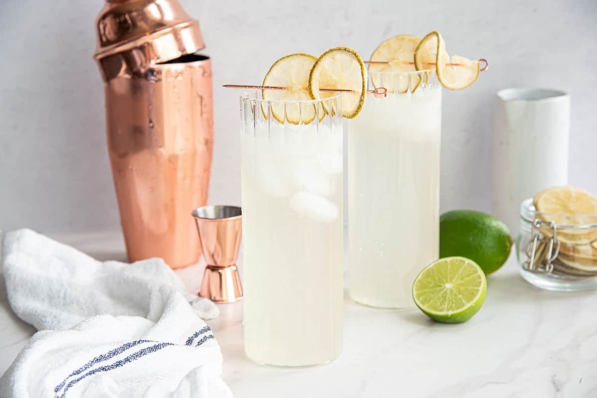 Two highballs with Gin Rickey Cocktail in them. Two highballs with Gin Rickey Cocktail in them.
