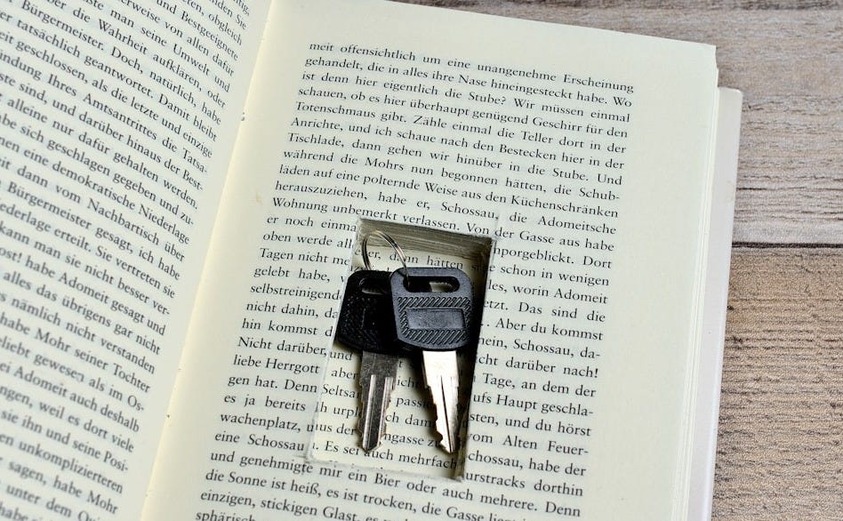 An open book with a pair of scissors sticking out of it An open book with a pair of scissors sticking out of it