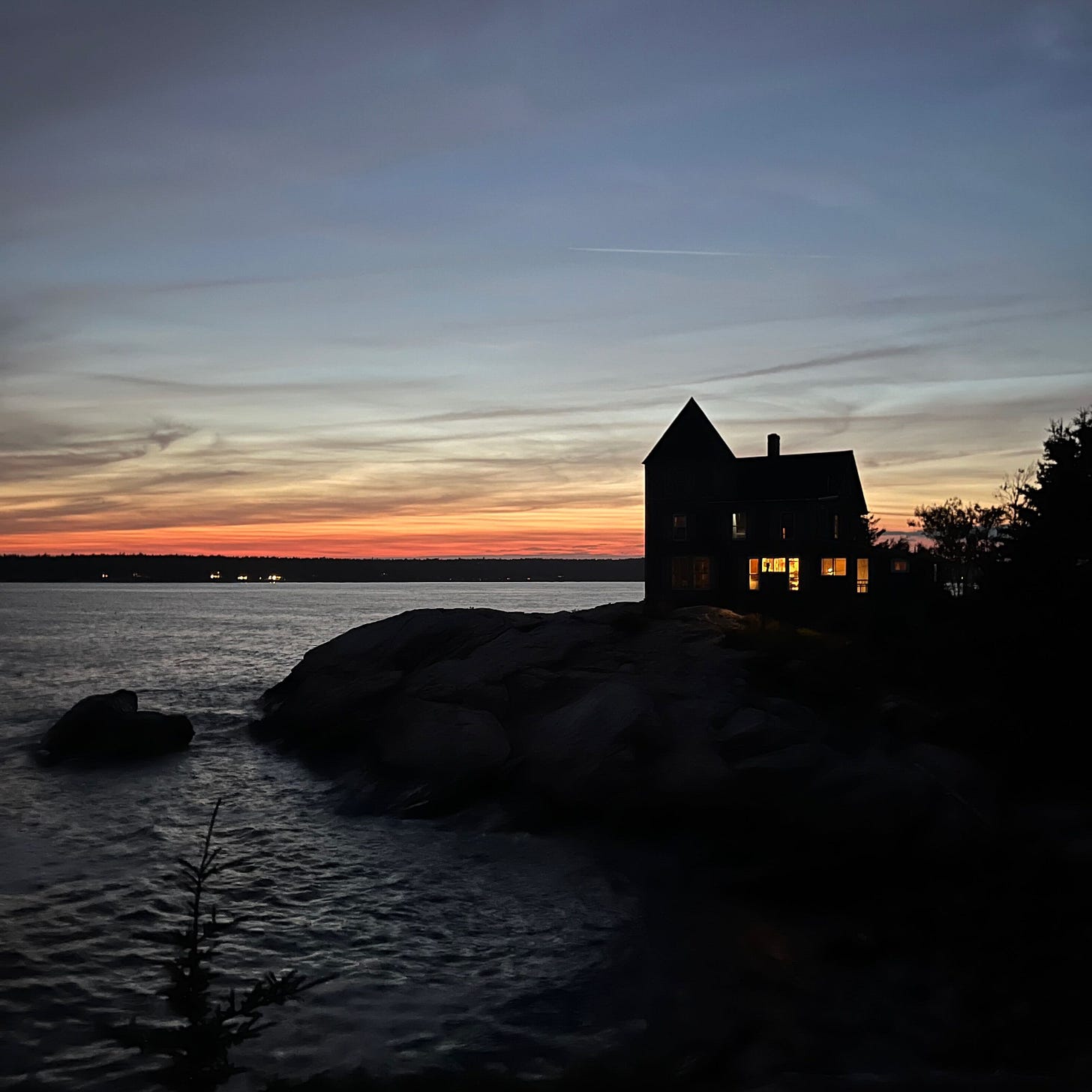 Silhouette of a shorefront home backlit by a sunset Silhouette of a shorefront home backlit by a sunset