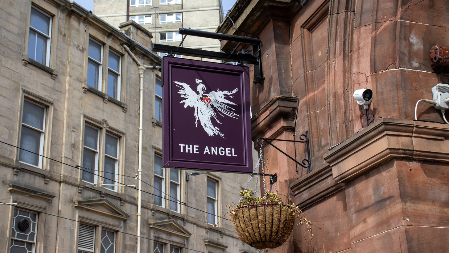 The purple pub sign with an illustration of a white Angel