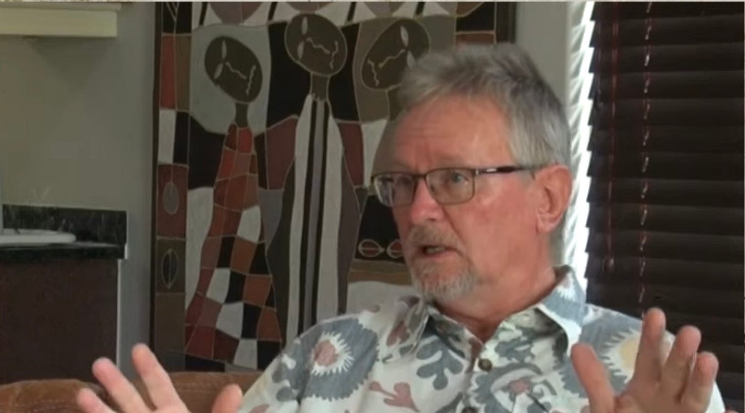 Photo of Richard Spoor with his hands up, speaking 