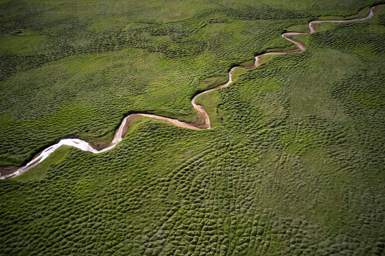 Amazing aerial landscape of flowing stream in green field stock photo