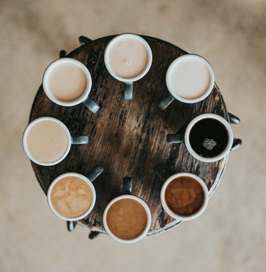 flat lay photography of eight coffee latte in mugs on round table