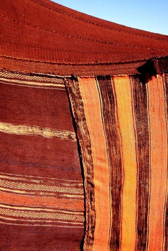This may contain: an orange and brown striped blanket with a blue sky in the backgroung This may contain: an orange and brown striped blanket with a blue sky in the backgroung