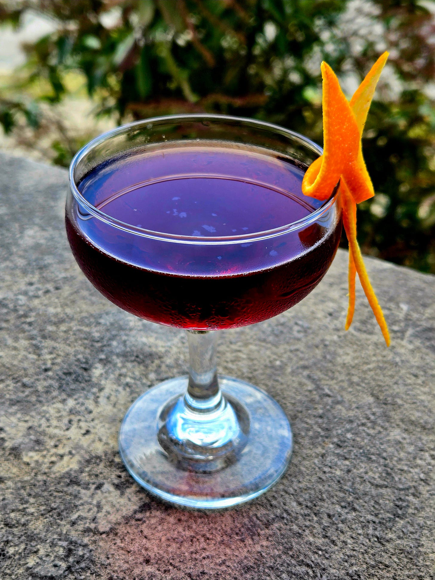 The Tipperary cocktail in a Coupe glass with orange twist garnish atop a stone wall. The Tipperary cocktail in a Coupe glass with orange twist garnish atop a stone wall.