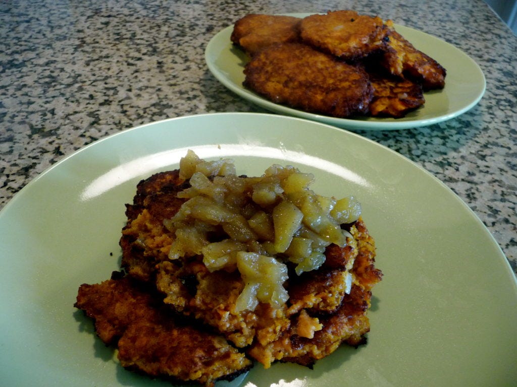 sweet potato latkes with applesauce on white plates