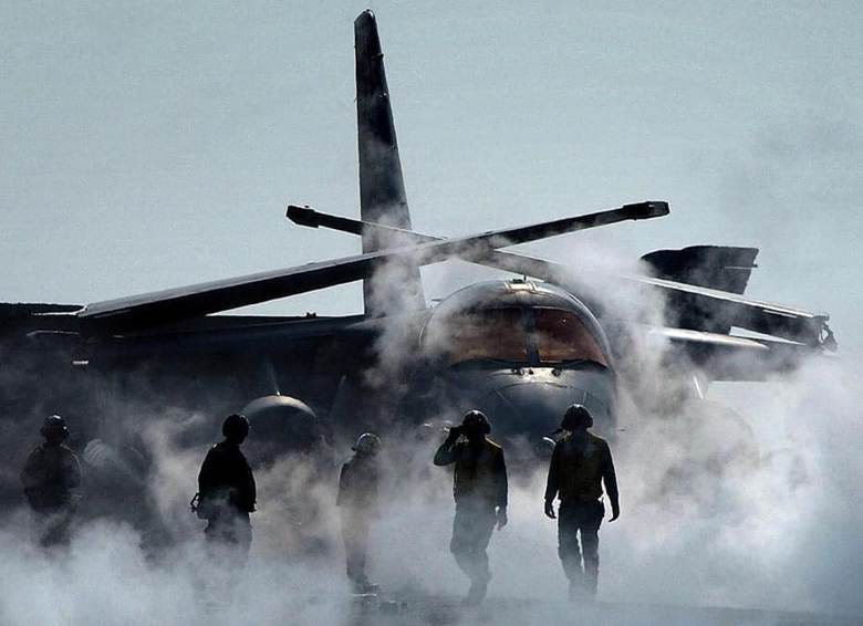 A group of people walking past a plane