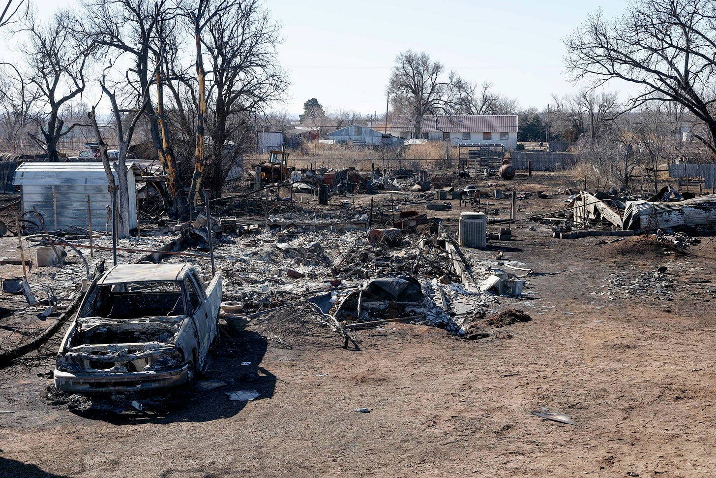 A home burned to the foundation and carcass of a truck. A home burned to the foundation and carcass of a truck.
