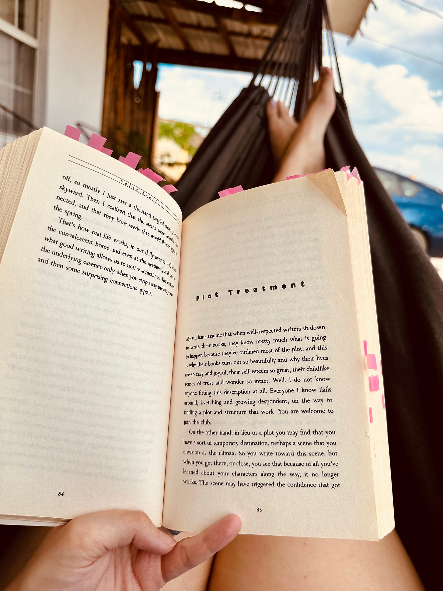 A visual representation of reading Bird by Bird. A person sits in a hammock, the book help open. In the background is blue, cloudy skies.
