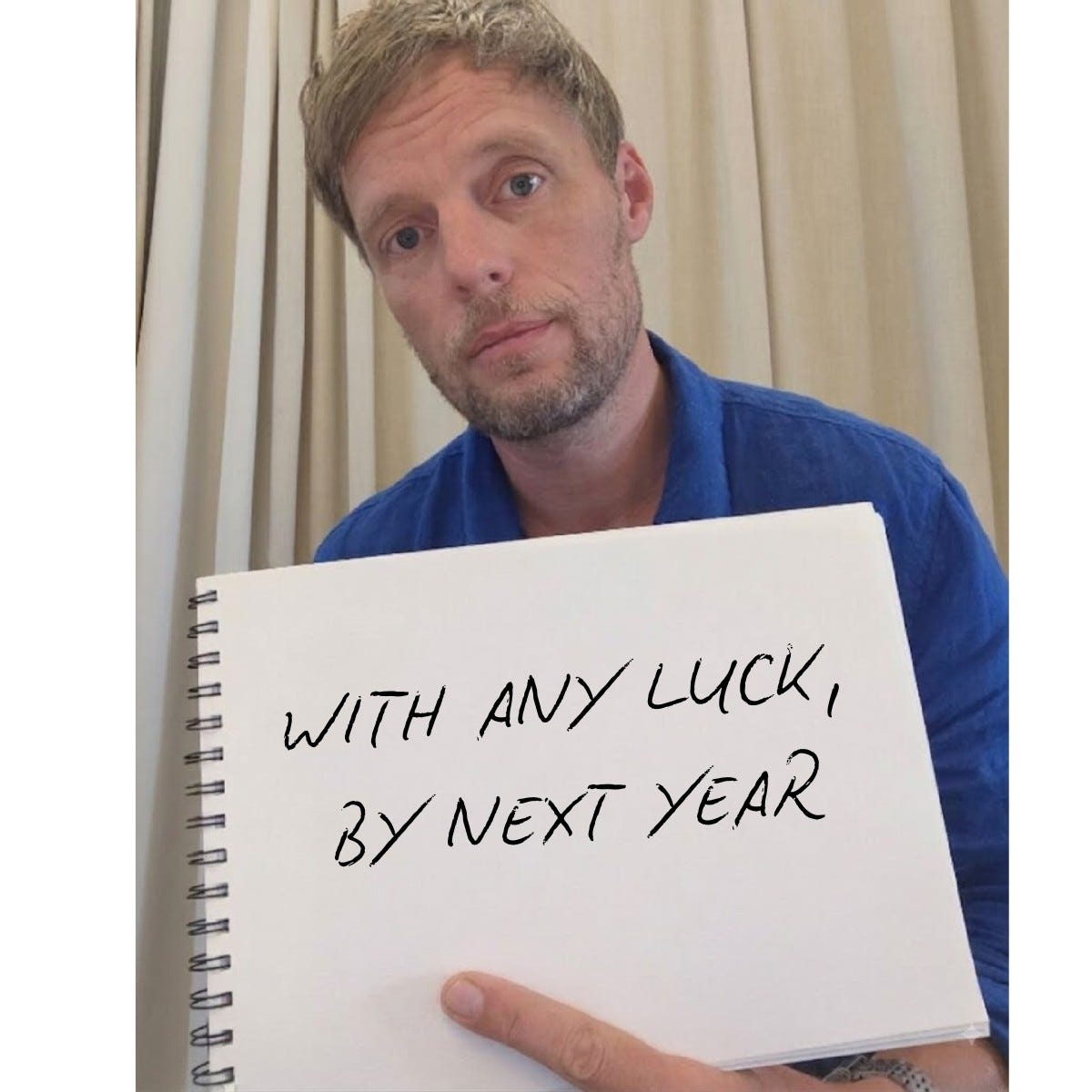 Same man and notebook. Handwritten: "WITH ANY LUCK, BY NEXT YEAR"