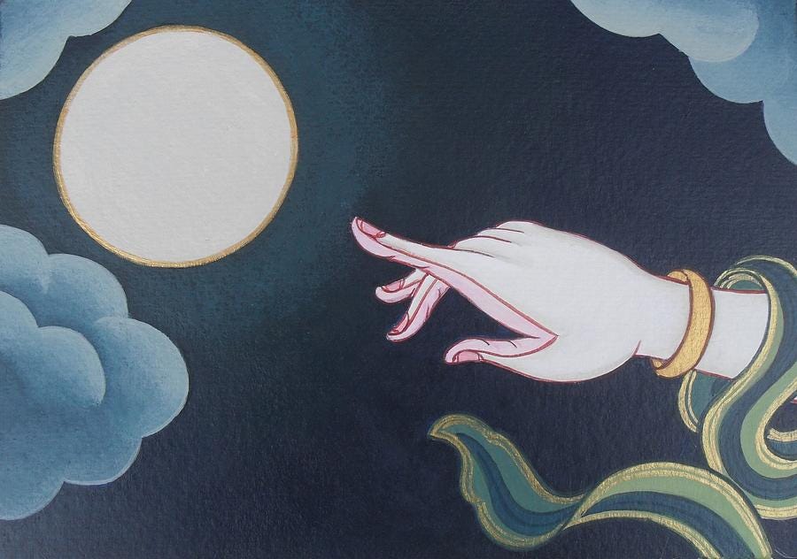 Finger pointing at the moon.