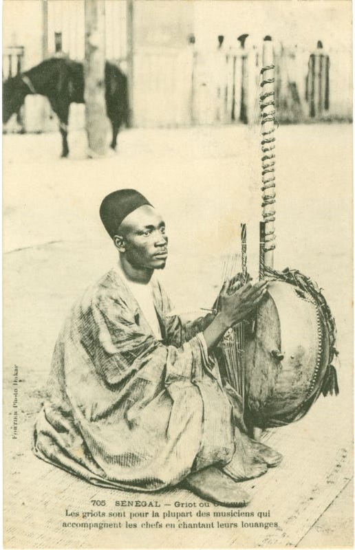 A West African griot (jali) plays a kora, a traditional harp, while singing oral histories and ancestral lineages. Griots belong to a hereditary caste of storytellers, musicians, and memory keepers who preserve cultural knowledge through music.