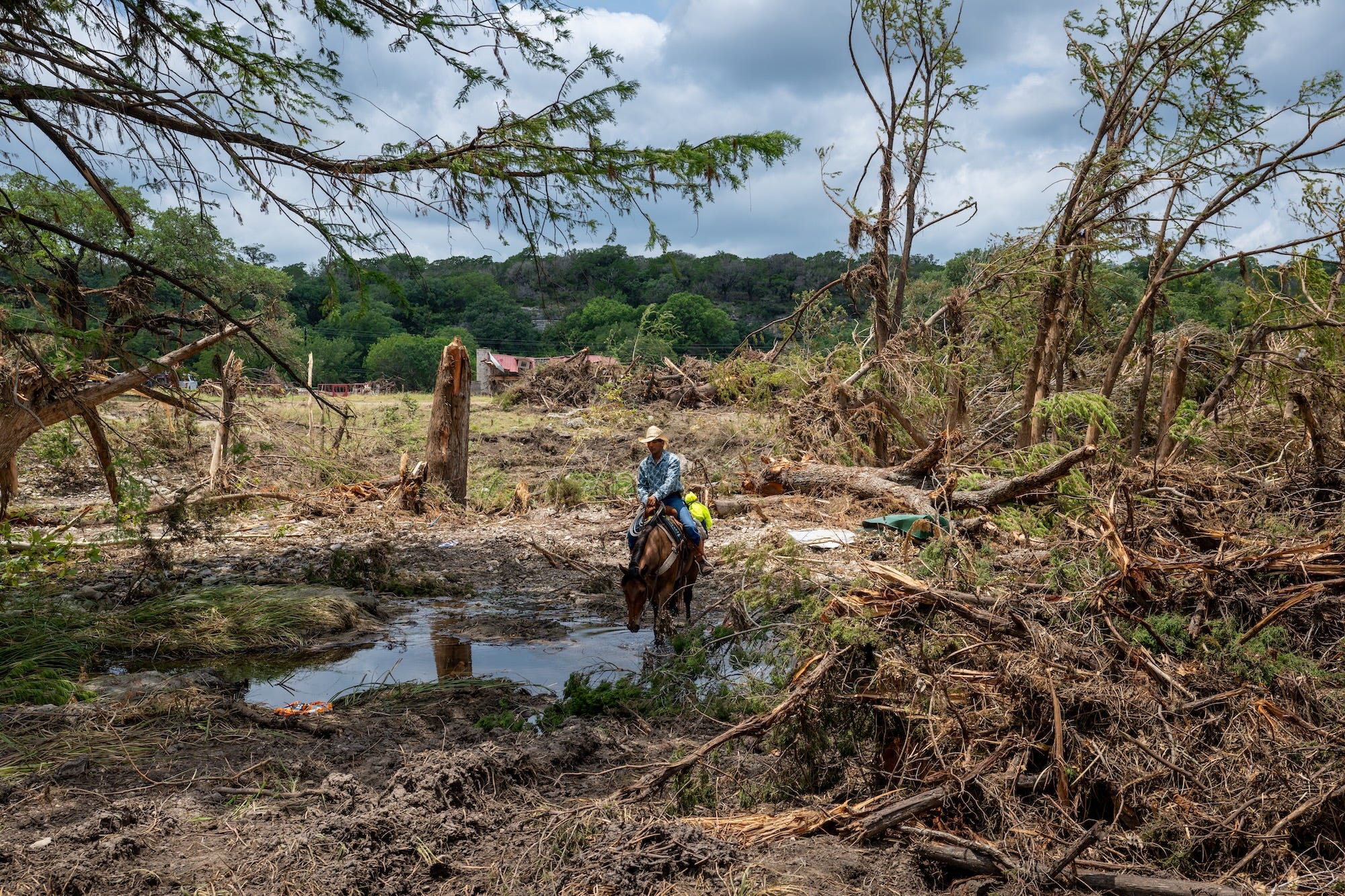A man on a horse wades through flood debris A man on a horse wades through flood debris