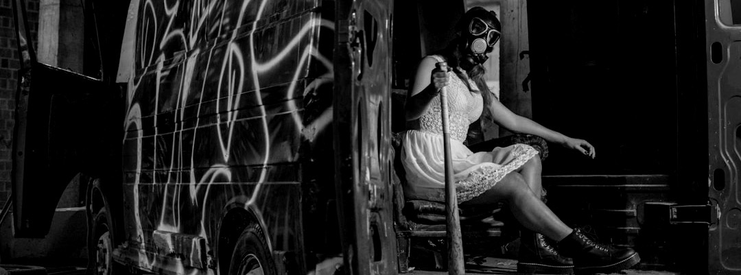 woman sitting in van while holding baseball bat