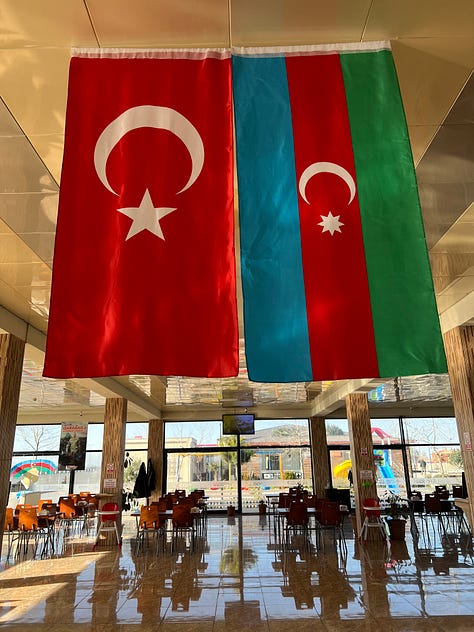 A patriotic roadside diner, and an Iranian village viewed from the roadside.