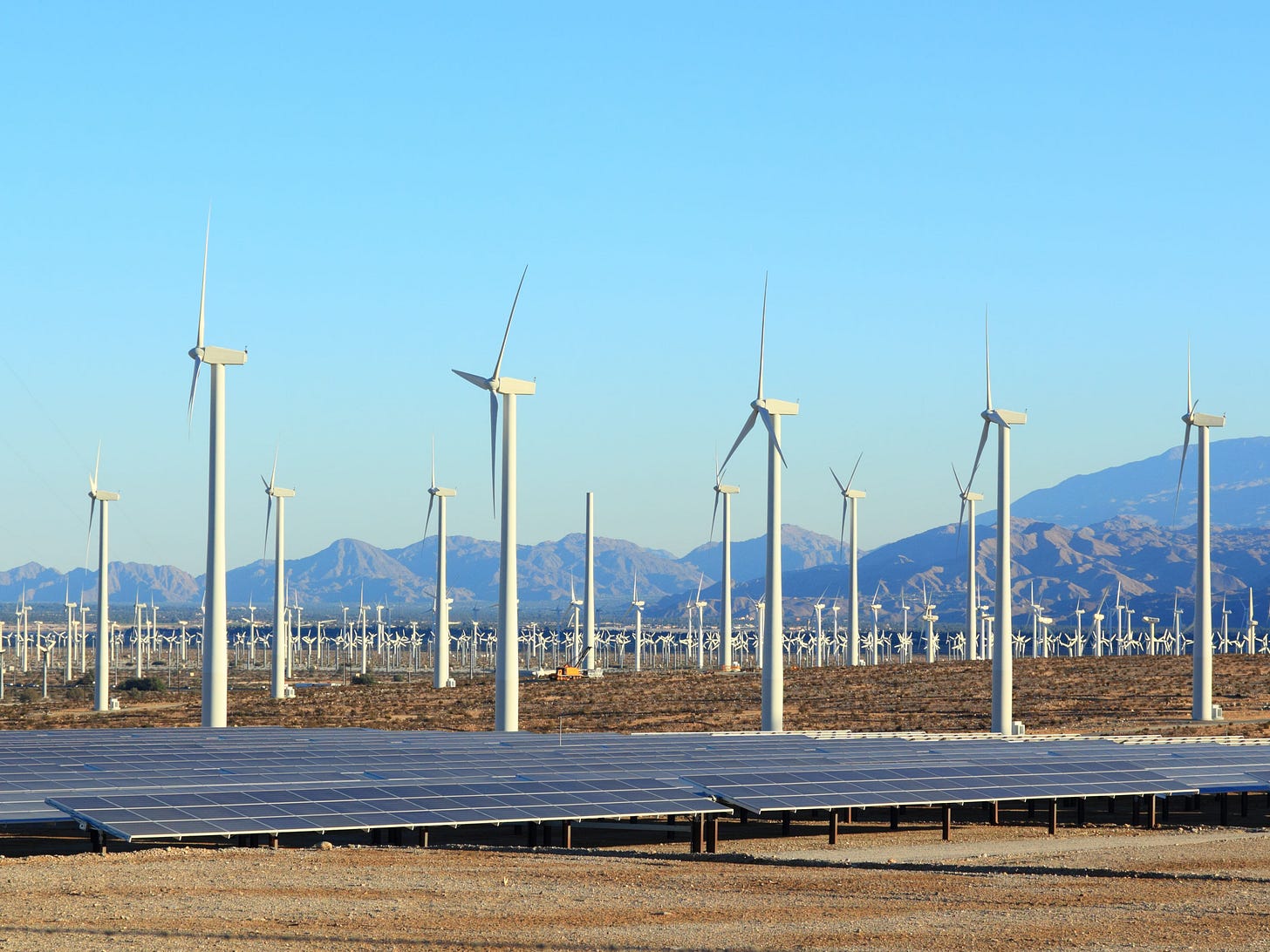A photo of solar panels and wind turbines.