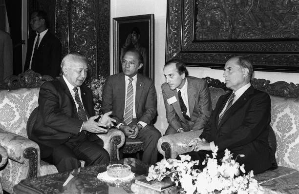 French President François Mitterrand chats with Indonesian President Mohamed Suharto while two translators look on, 16 September 1986 in Djakarta,...
