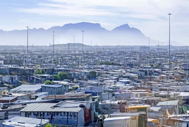 Shanty town with a mountain in the distance Shanty town with a mountain in the distance