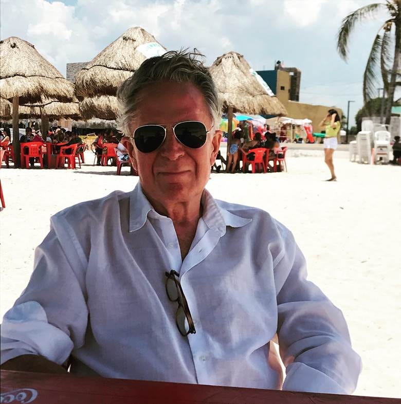A person wearing sunglasses and sitting at a table

Description automatically generated