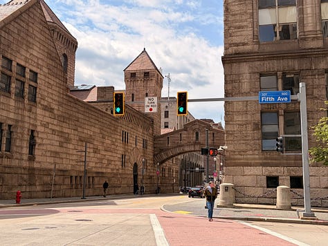 building, sky, street, sidewalk, traffic light