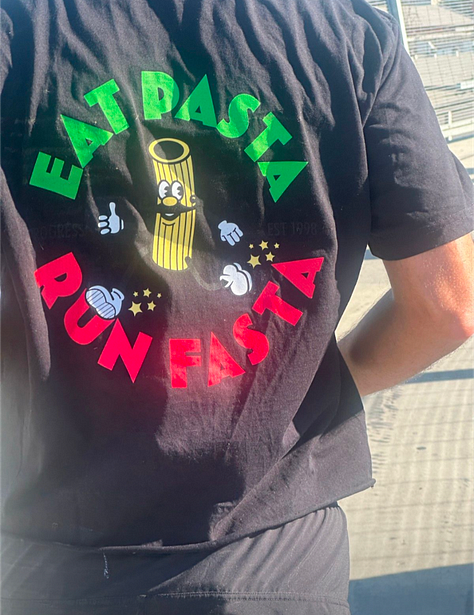 A photo of people running across the 6th St Bridge, past the old American Apparel building, and my tshirt saying EAT PASTA RUN FASTA