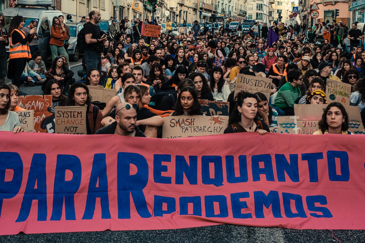 Activists sitting down and listening to interventions during the 23 Nov. climate march in Lisbon.