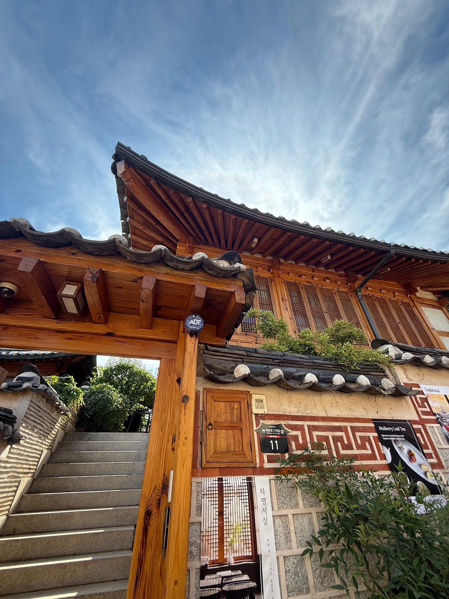 A traditional Korean tea house featuring wooden lattice windows and framed against a bright blue sky. A traditional Korean tea house featuring wooden lattice windows and framed against a bright blue sky.