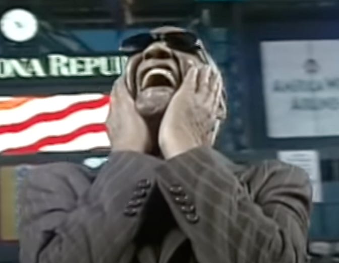 A person in a suit laughing

Description automatically generated