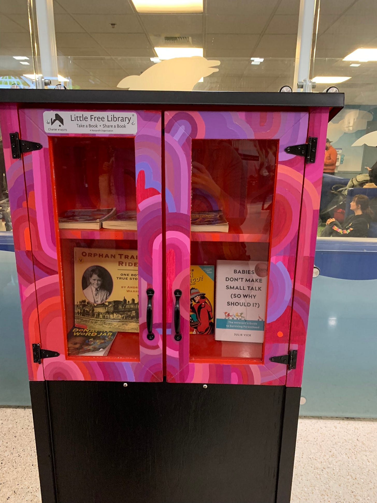 A photo of my book in an artistically decorated little free library at the Seattle Airport A photo of my book in an artistically decorated little free library at the Seattle Airport