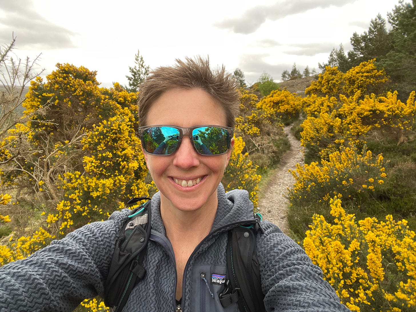 woman with sunglasses in front of yellow bushes