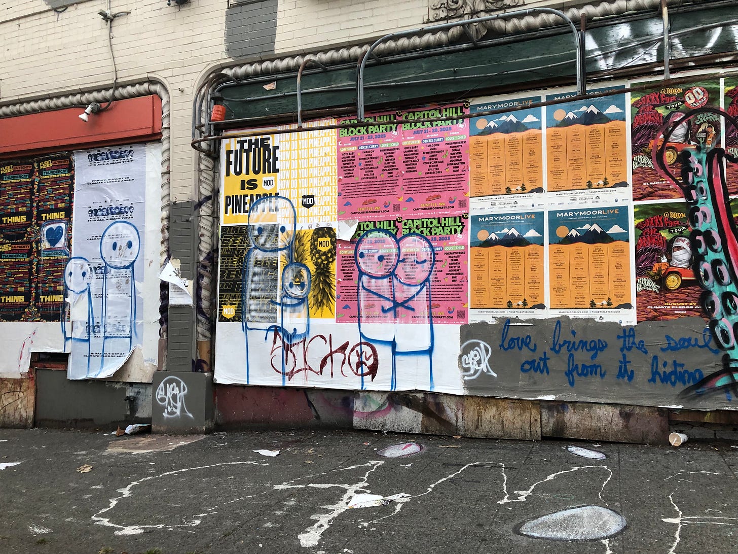 a photo of some layered posters and street art in Seattle