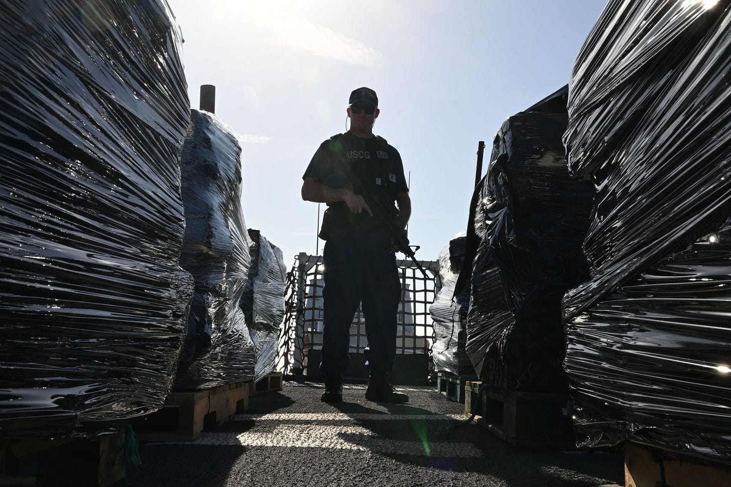 US Coast Guard Cutter Resolute crewman guards 12,600 pounds of cocaine confiscated from smuggling boats during a recent patrol.