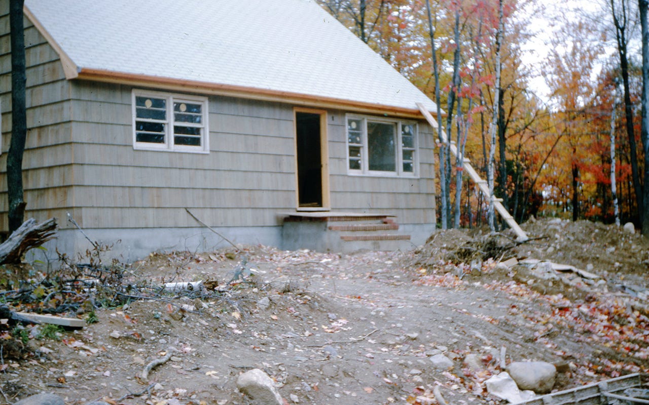 Photo of a new home in a forest in fall