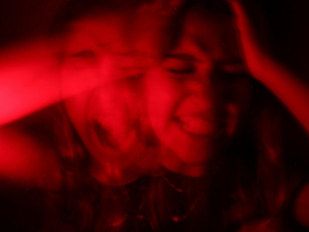 a woman is smiling while holding her hands up