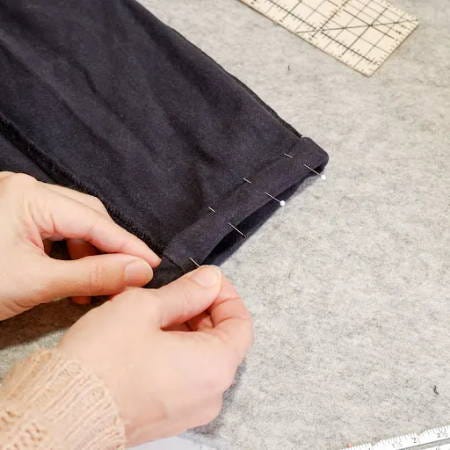 adding pins to a hem of pants ready to be sewn