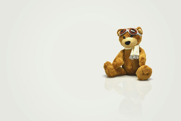 A child’s stuffed teddy bear sitting in an empty white room. A child’s stuffed teddy bear sitting in an empty white room.