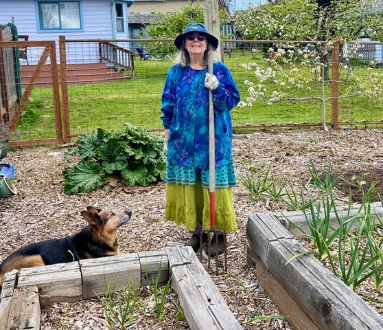 Kate in her garden with apple trees, flowers and vegetable plots.