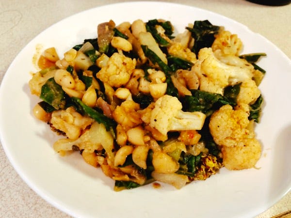 Turmeric Quinoa and Red Beans with Cauliflower and Chard from the How Not to Diet cookbook in a white bowl.