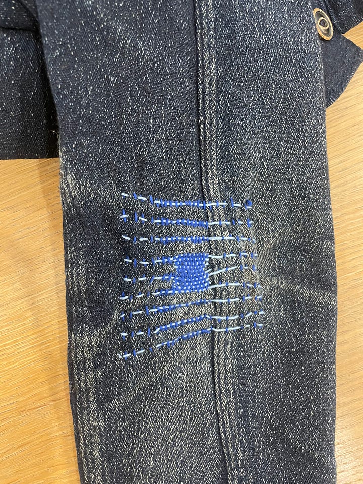 Two examples of darning, one on the knee of pants and the other on the elbow of a jacket