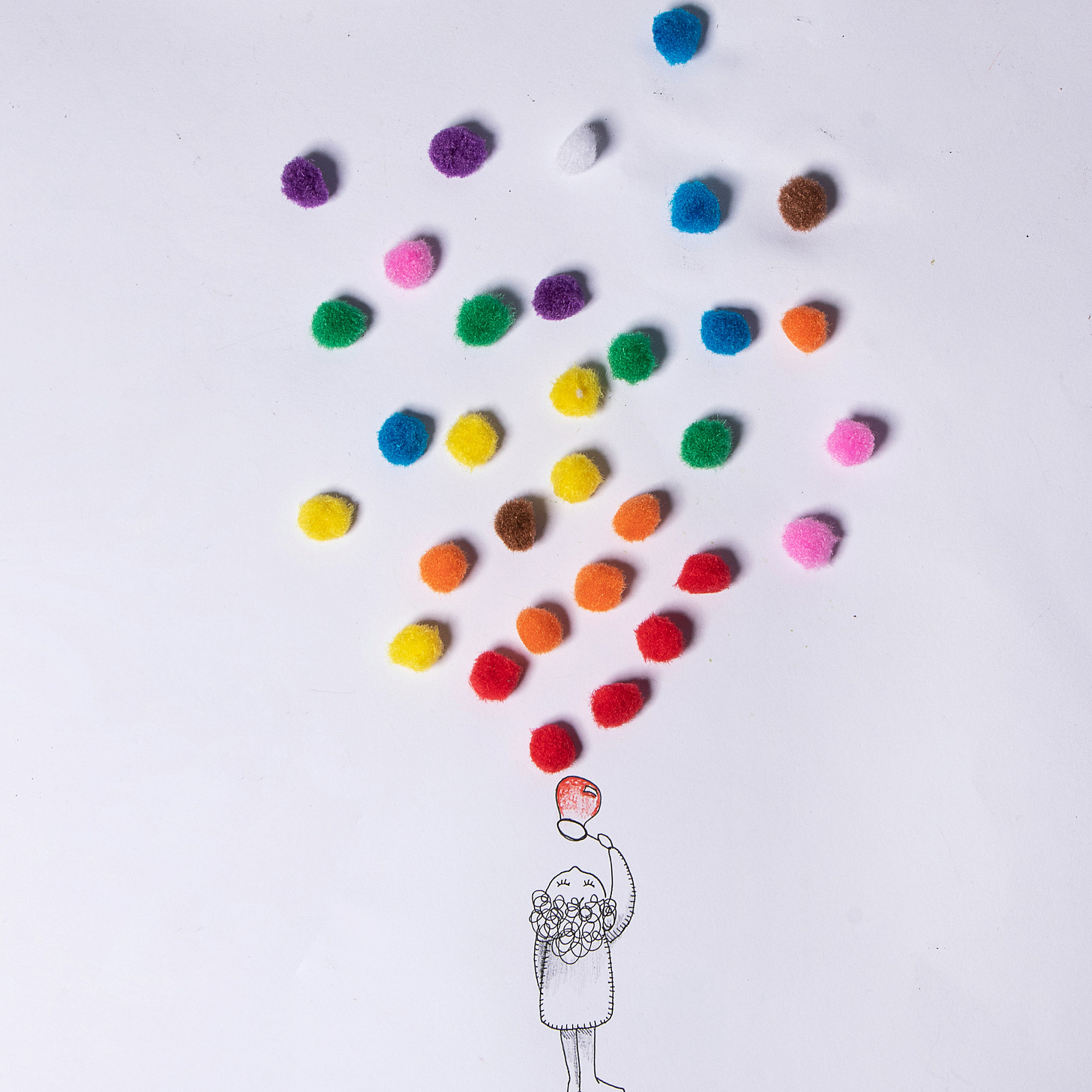A drawing of a person blowing bubbles. Above are multicolored, textured balls (pom-poms)
