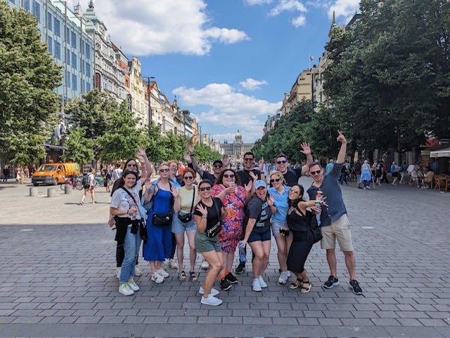 Group of speakers and volunteers post for a picture during walking tour of Prague at Community Rebellion 2023. 