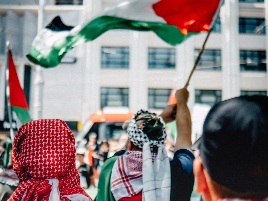 a group of people holding flags in front of a building